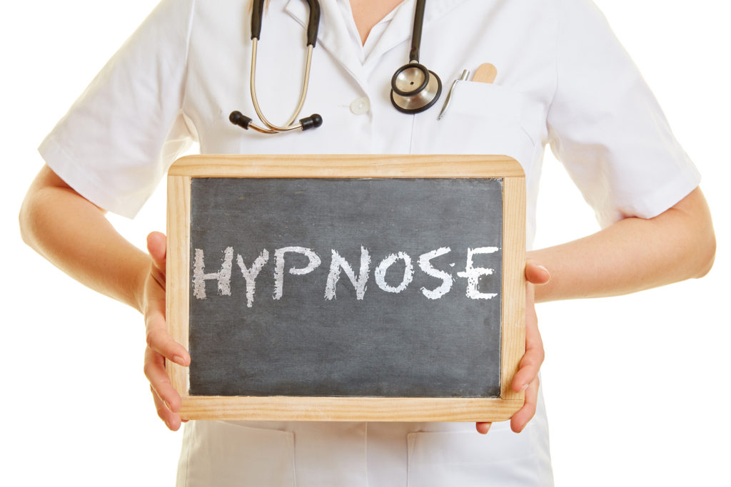 Médecin tenant une ardoise avec le mot hypnose
